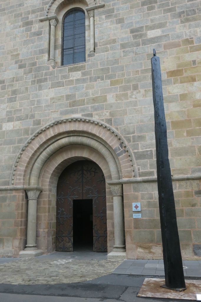 Entrée de l'abbatiale avec une sculpture monumentale en bois brut calciné de Christian Lapie 